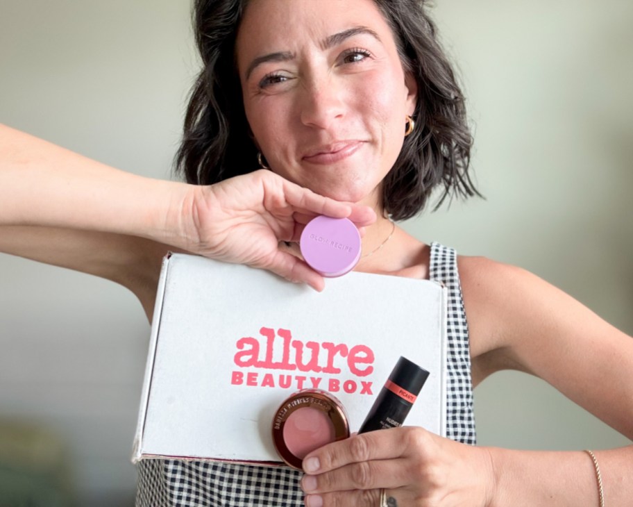 woman holding white box, lip balm, compact, and blush stick