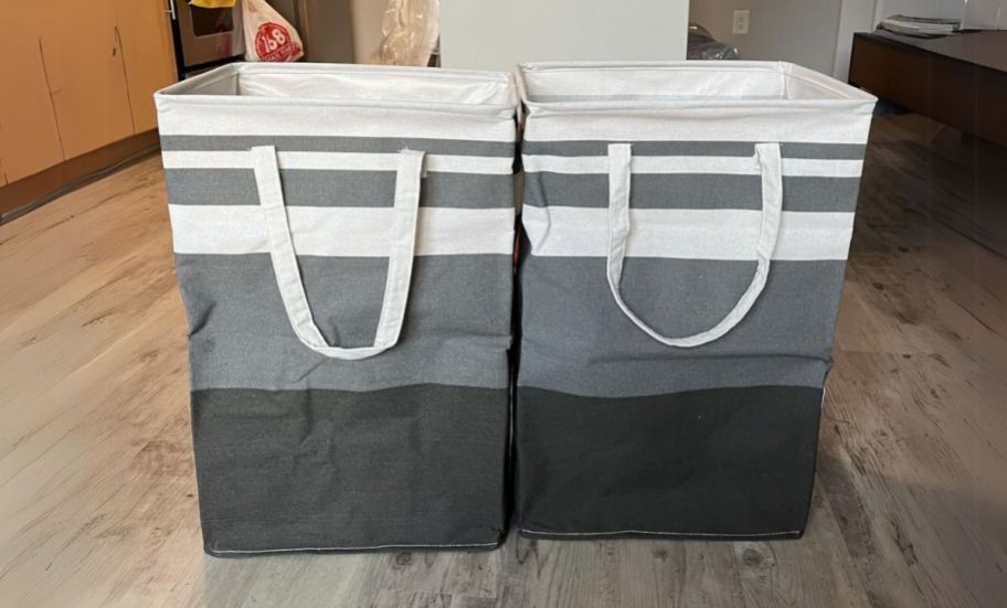 2 white and gray striped collapsible laundry baskets 