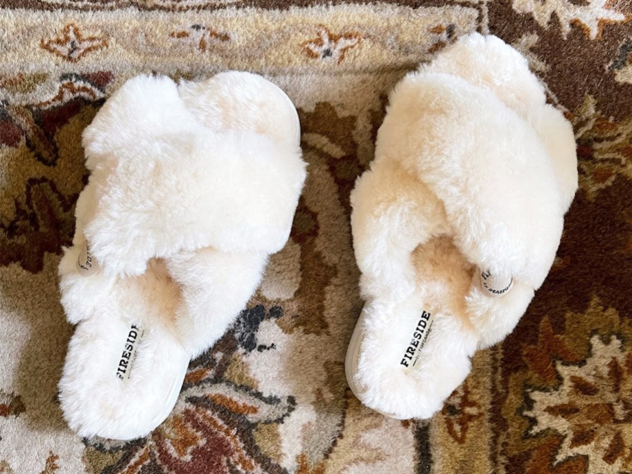 pair of white crossband slide slippers on rug