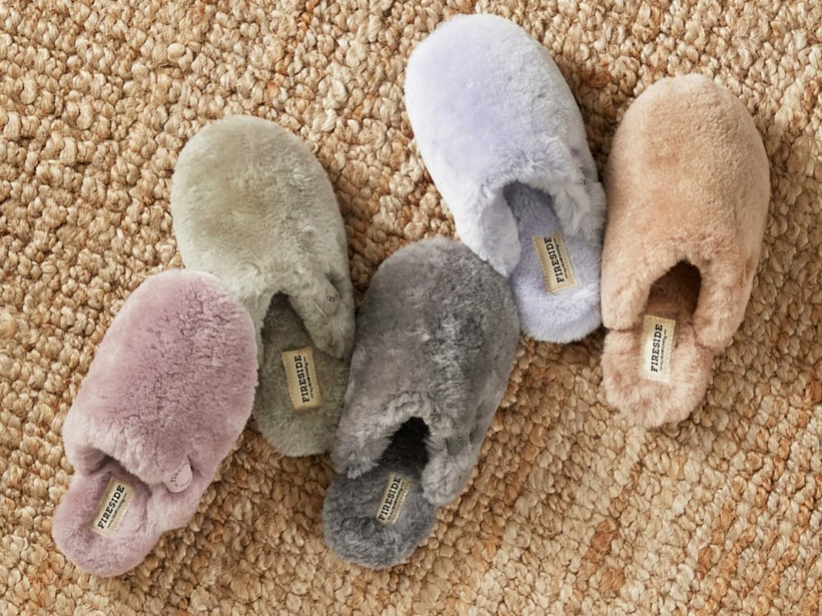 5 fuzzy slippers in various colors on rug