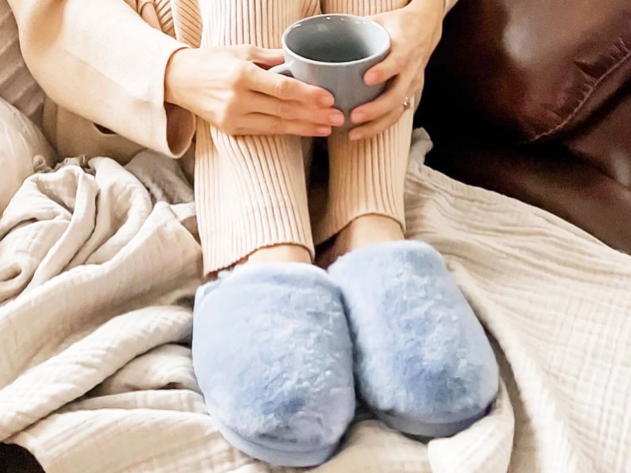 woman wearing slippers and holding cup of coffee