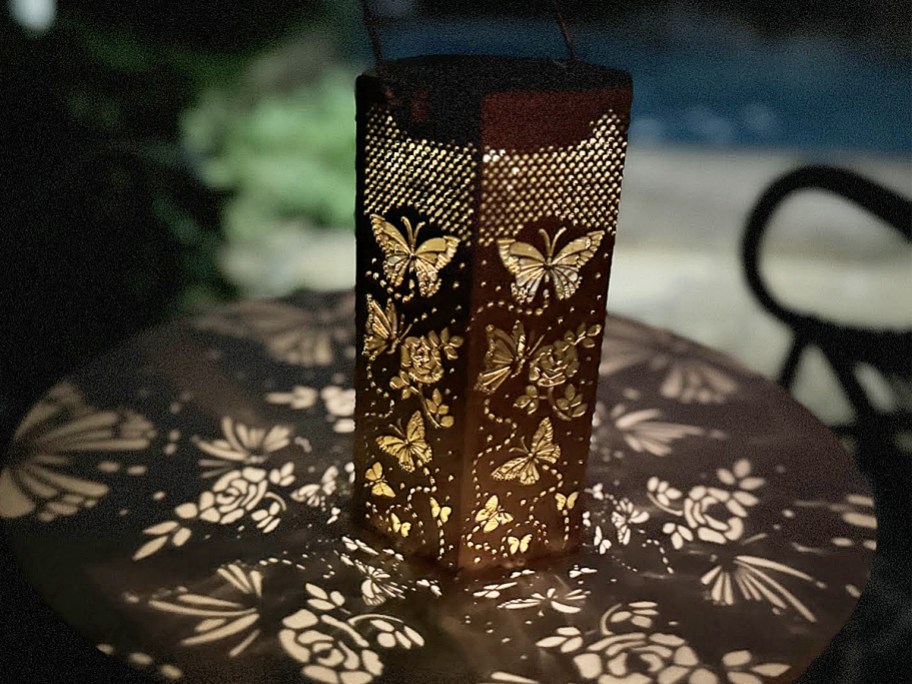 solar lantern casting butterfly pattern on table