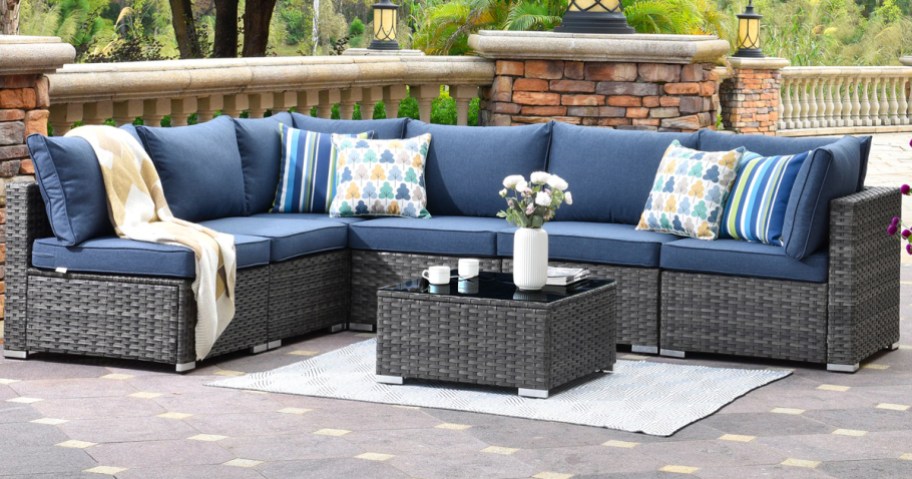 grey outdoor sectional with blue cushions and matching coffee table