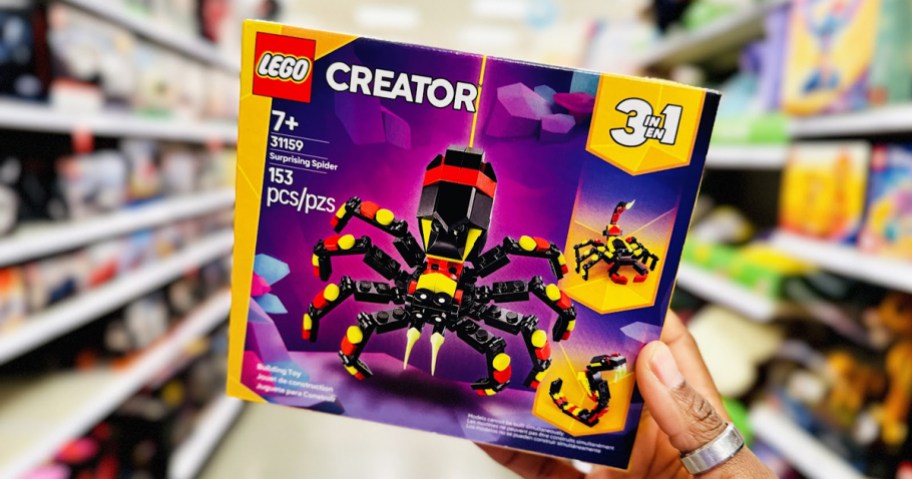 hand holding up the LEGO Creator 3-in-1 Surprising Spider set in store