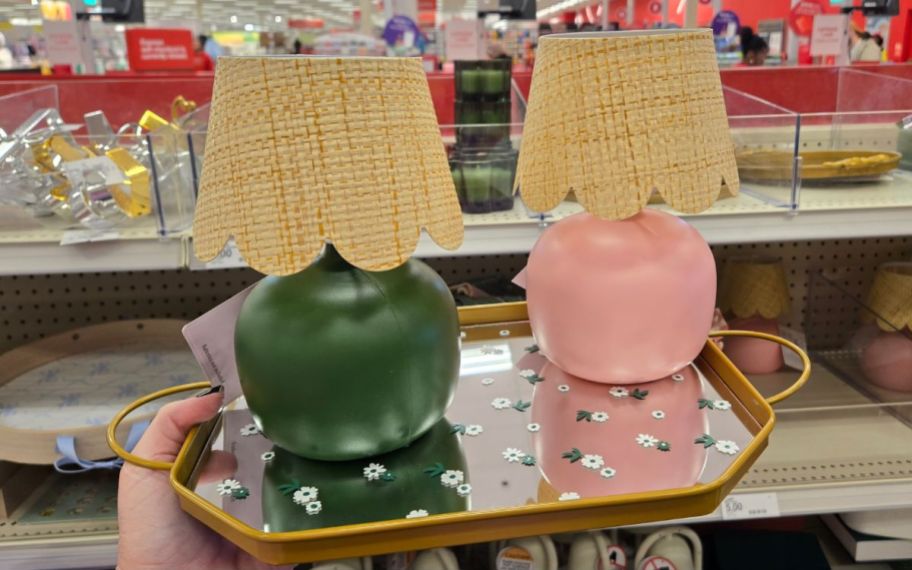 a womans hand holding a mirrored tray with 2 mini lamps displayed on it