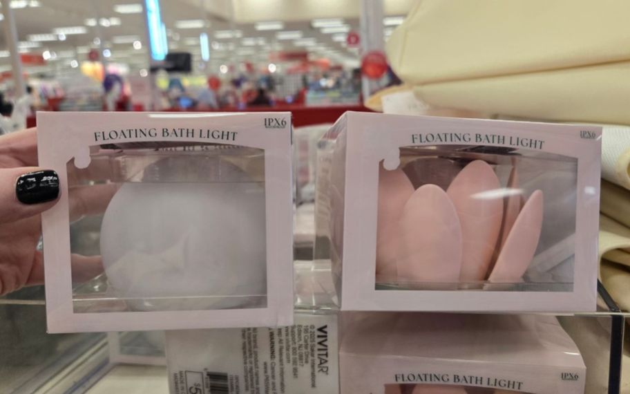 a womans hand holding a boxed bath light