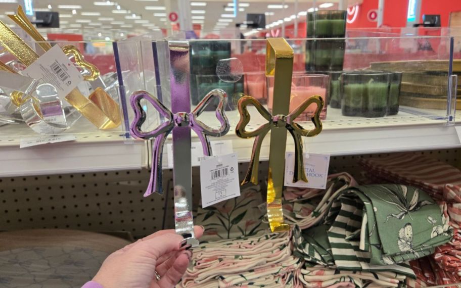 a womans hand holding two door wreath hangers