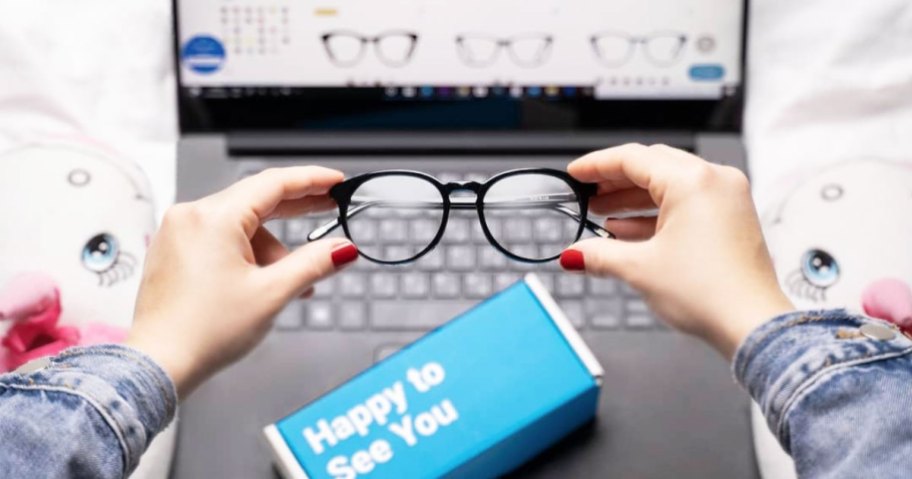 woman holding glasses in front of laptop with glassesusa pulled up on computer