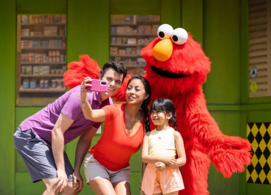 Family taking pictures with elmo at sesame place