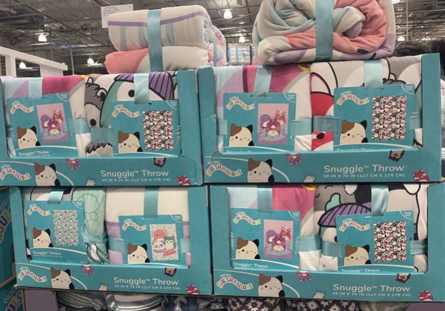 folded squishmallows throw blankets on display in a costco store