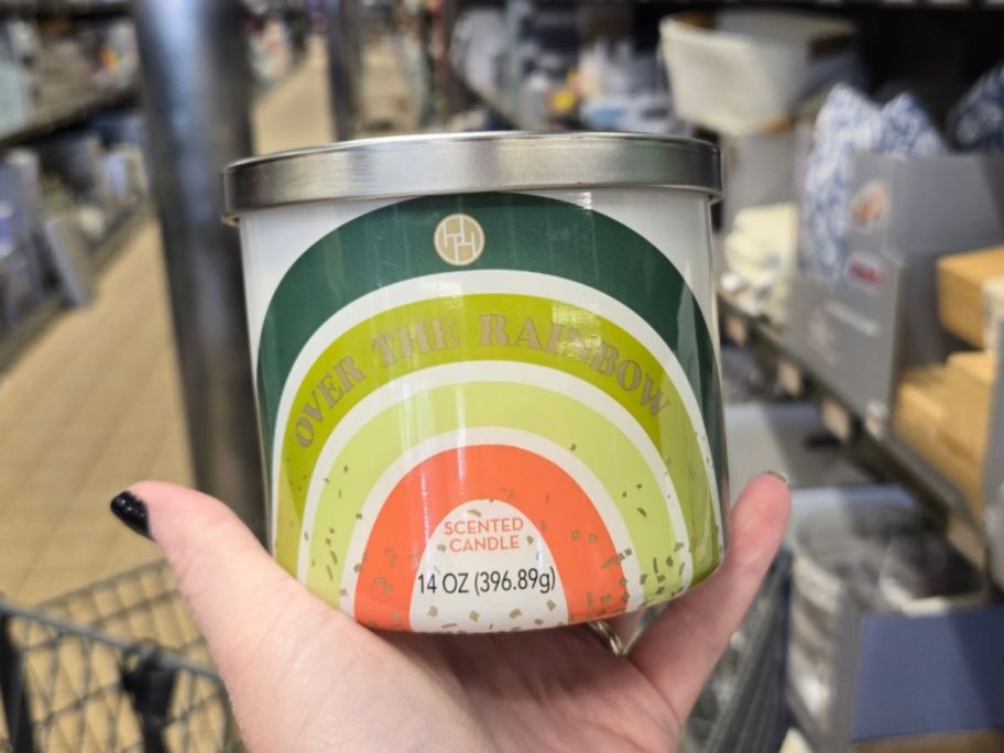 A person holding an Aldi Huntington Home Over the Rainbow Scented Candle