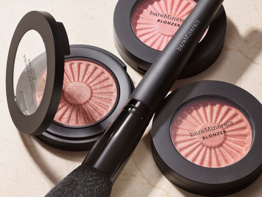 3 open compacts of bareMinerals Gen Nude Blonzer with a makeup brush