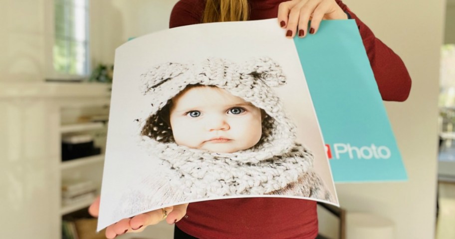 Woman holding a large photo poster with blue envelope