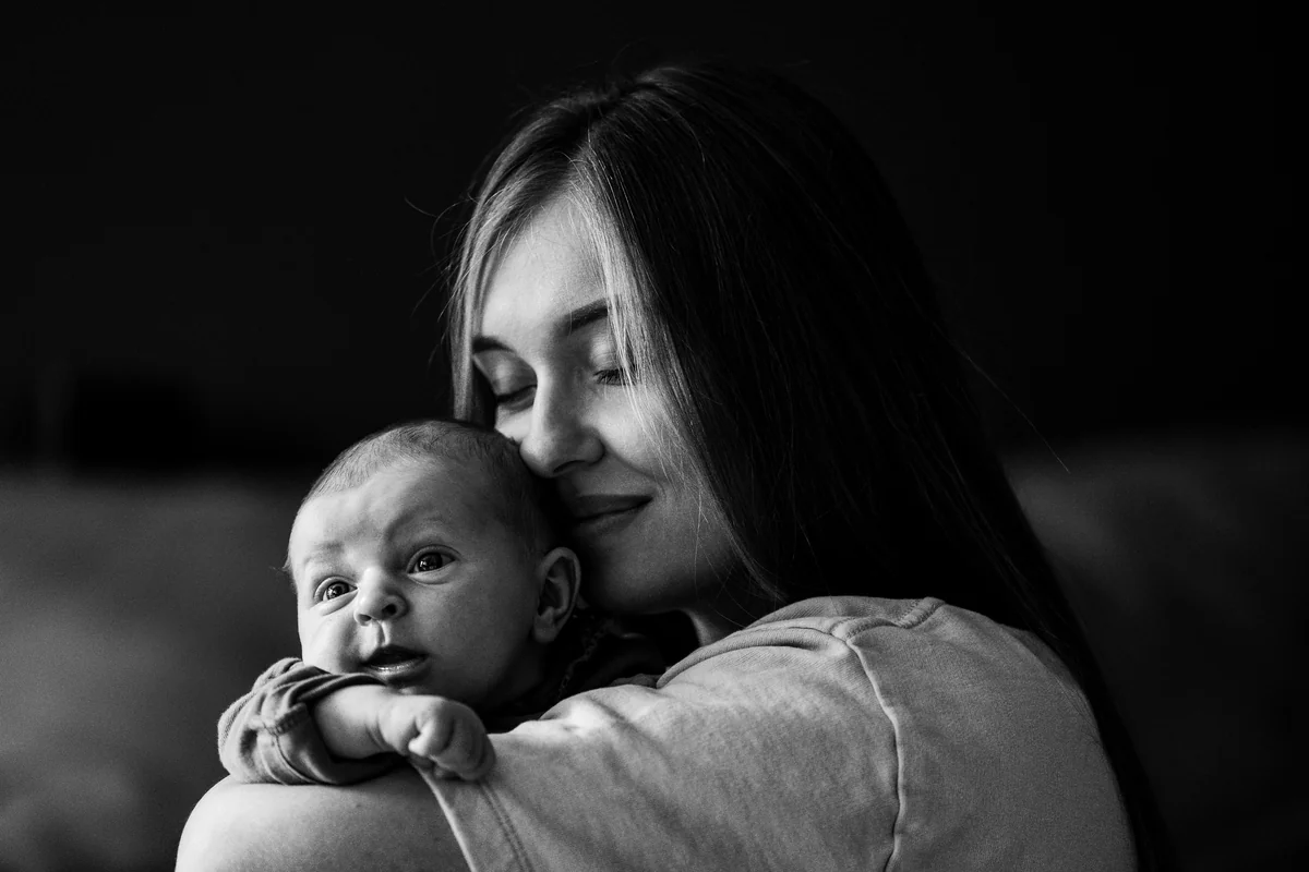 a woman holding a baby in her arms - infant child care - Baby gear and nursery furniture discount offers