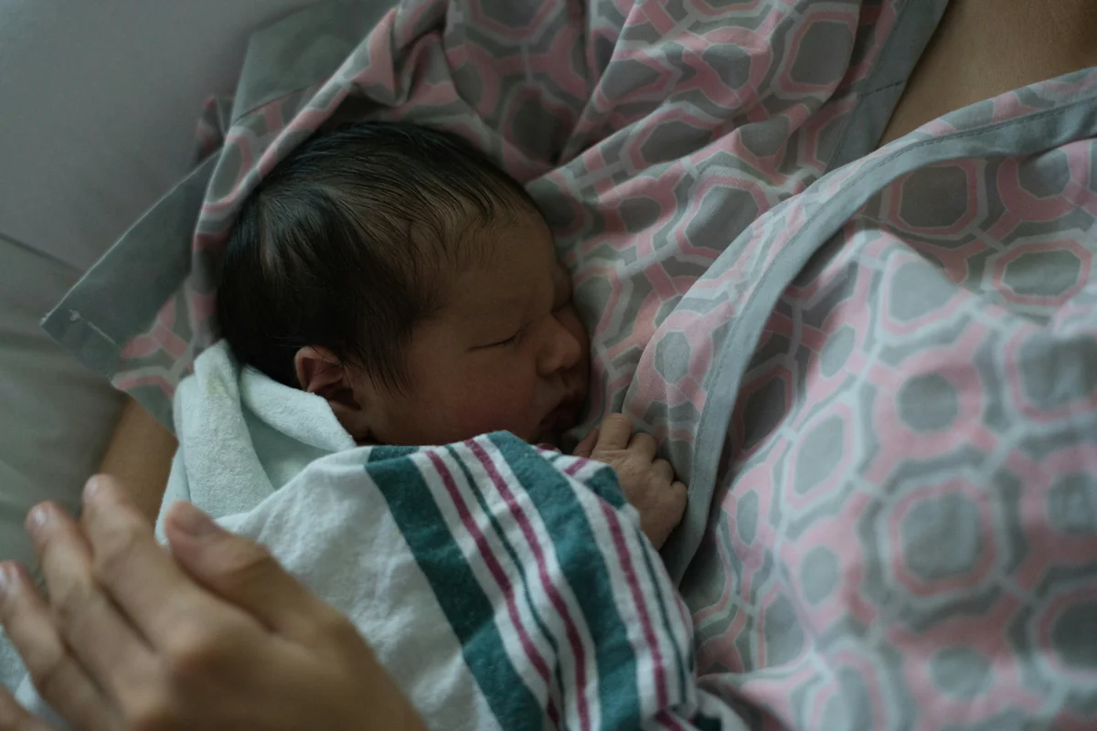 Newborn baby sleeping peacefully on a parent. - infant child care - Baby gear and nursery furniture discount offers