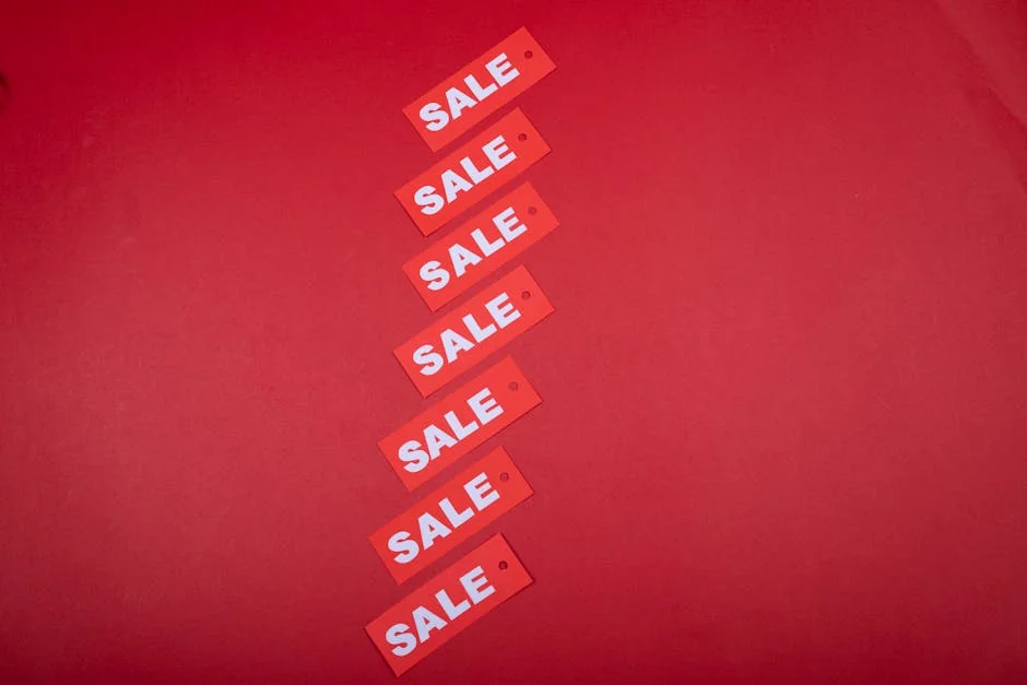 Top view of red sale tags arranged on a vibrant red background for commercial use. - how to combine manufacturer coupons with store sales