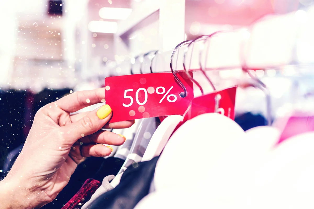 person holding red and white love print gift wrapper - comparison of best coupon sites for fashion