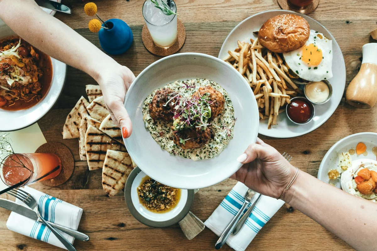 person holding white plate with food - local restaurant coupons and dining out deals