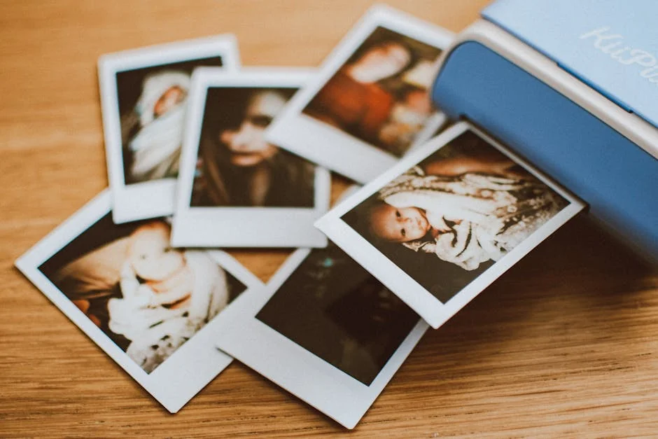 A collection of instant photo prints scattered on a wooden table, featuring personal moments. - photo printing coupons and personalized gift deals