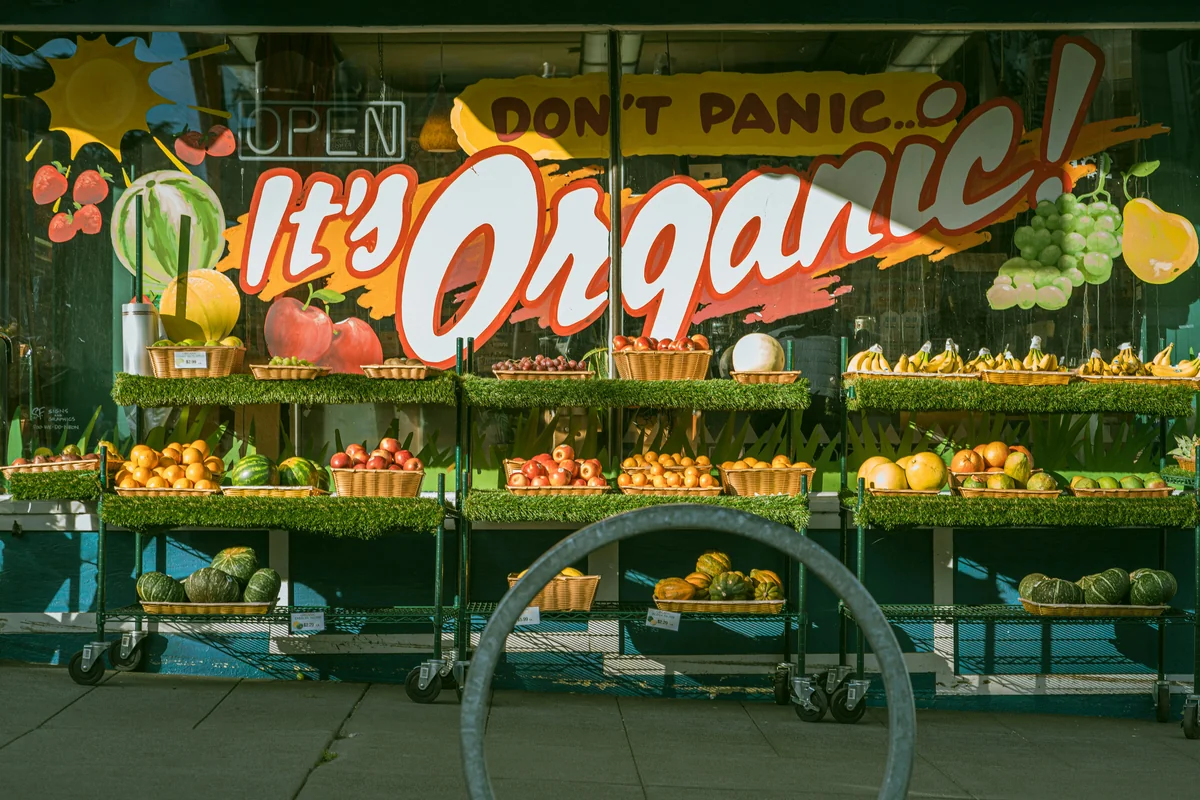 a display in a store filled with lots of fresh produce - how to save money on organic groceries with coupons