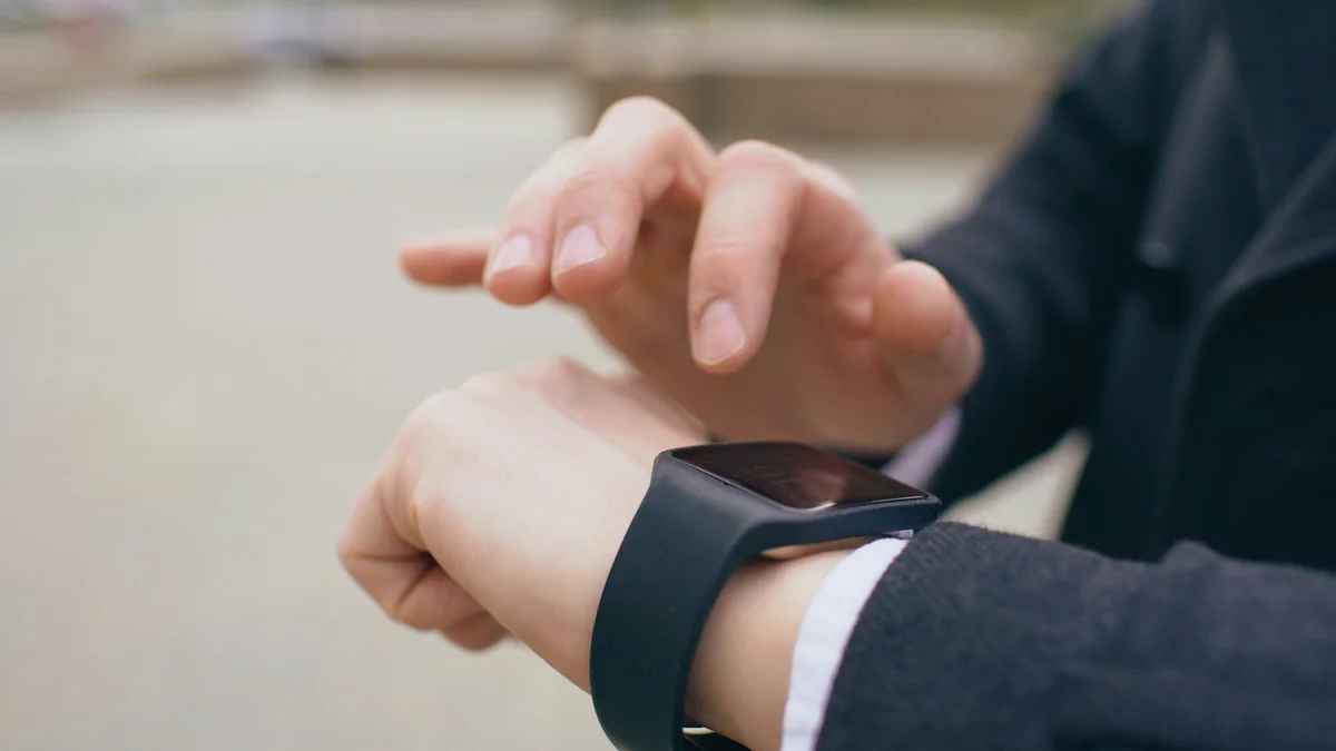 Closeup of businessman using his smartwatch touchscreen standing on street - smart watch and wearable tech promo codes 2026