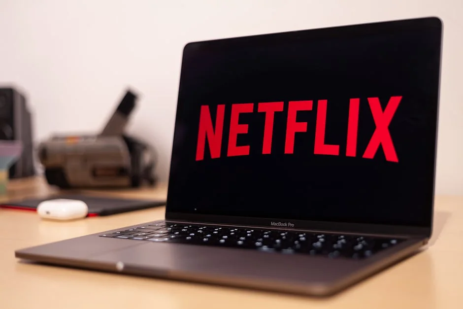 Close-up of a MacBook Pro showing Netflix on the screen in a modern workspace. - subscription renewal discounts for streaming services
