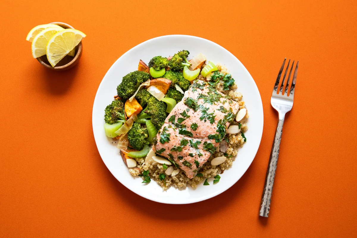 Healthy salmon + veggies + quinoa dish I made for lunch on a orange background for contrast. - top rated meal kit delivery service discounts