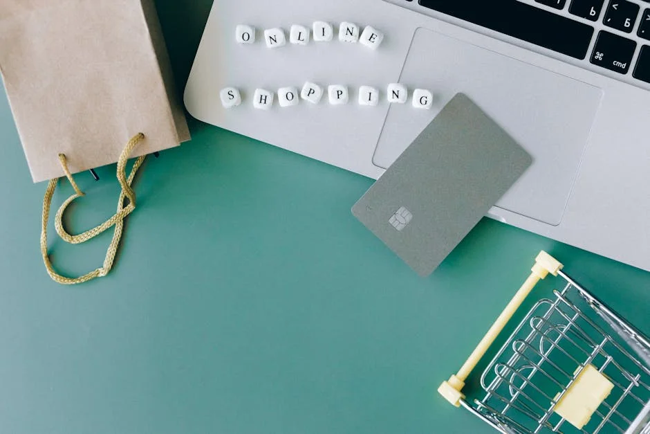 Flat lay of online shopping essentials with laptop, card, and shopping cart. - verified amazon promo codes for electronics