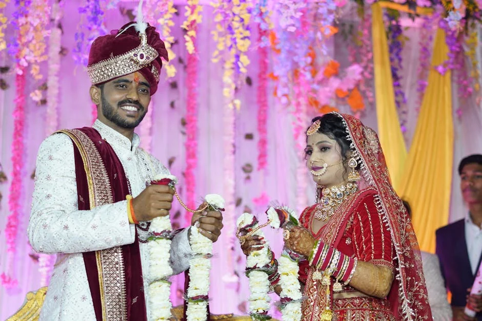 A vibrant Indian bride and groom during a traditional wedding ceremony, adorned with floral garlands. - marriage ceremony celebration - Wedding dress and bridal accessory promo codes