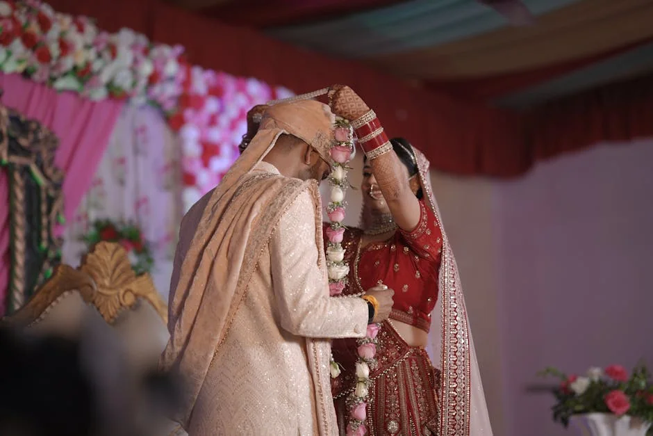 A bride and groom exchange garlands during a traditional Indian wedding ceremony. - marriage ceremony celebration - Wedding dress and bridal accessory promo codes